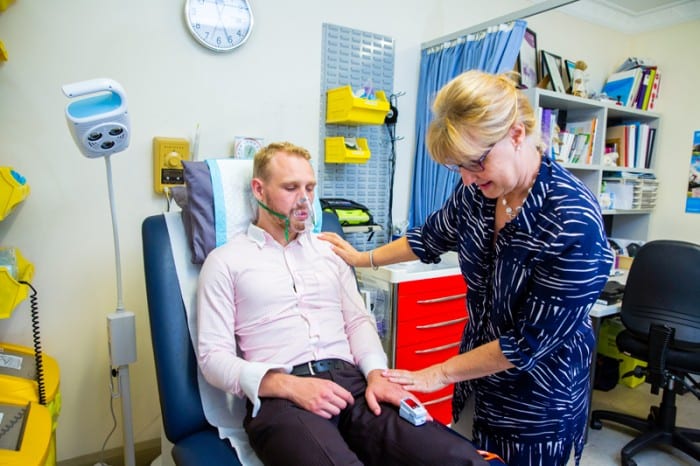 Man with ventilator is treated by doctor